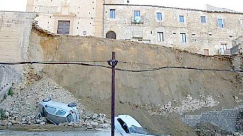  PIAZZA ARMERINA. Una coperta “cementizia” posata sul pendio a rischio per evitare altri smottamenti dopo il cedimento di tre mesi fa. Iniziata l’installazione del telo speciale su tutto il fronte di 450 metri sotto la chiesa del Carmine. E potrebbero essere utilizzati anche dei rocciatori esperti in tecniche alpinistiche. Lo scorso maggio era crollato il muro in blocchi di pietra, trascinando giù tonnellate di detriti e anche due automobili.  Entra nel vivo ora il progetto da 60 mila euro per la protezione del pendio da pioggia ed escursioni termiche dopo il benestare alla relazione tecnica della Gcs, la Geo Consulting Service, la ditta di Caltagirone che ha messo nero su bianco i termini dell’intervento dopo aver ricevuto l’incarico con ordinanza. La soluzione del “telone” si sta adottando su un fronte largo 28 metri e alto in media 12 metri, mediante “Concrete Canvas”, un geotessile impregnato cementizio flessibile che si indurisce una volta idratato per formare un sottile strato cementizio durevole, impermeabile all’acqua e resistente al fuoco.    Fonte: R.Palermo, "Il crollo a Piazza, si posiziona il telo speciale", in Il Giornale di Sicilia, 17 Agosto 2015 Link: http://goo.gl/fHSRnp